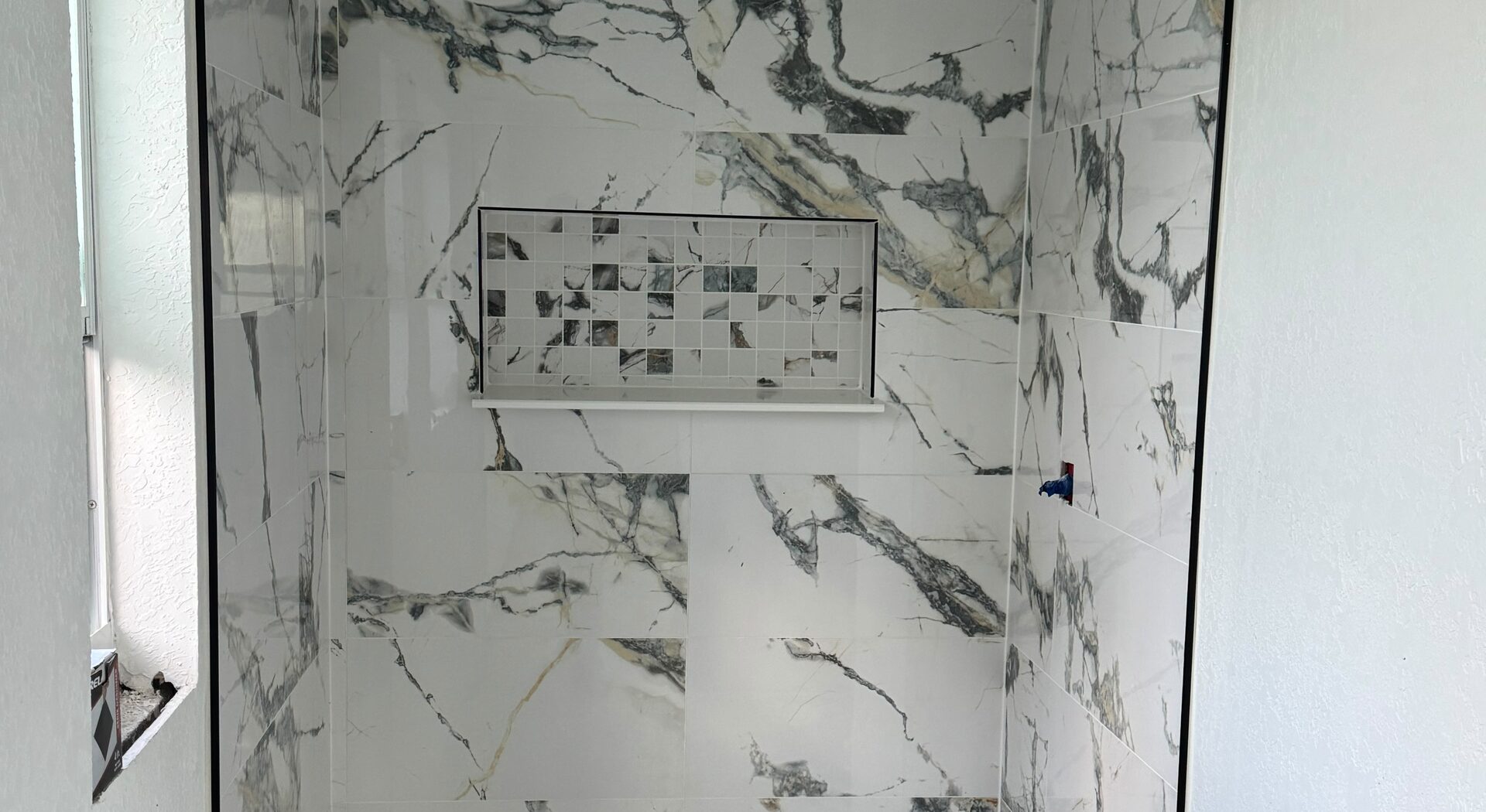 Book-matched marble tile shower installation