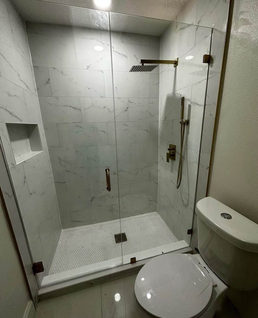 Walk-in shower with brass fixtures and penny tile